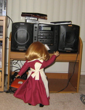 Nellie reaches for some DVDs strewn on my stereo.