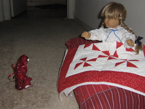 A small figure wrapped in wrapping paper confronts Kirsten.