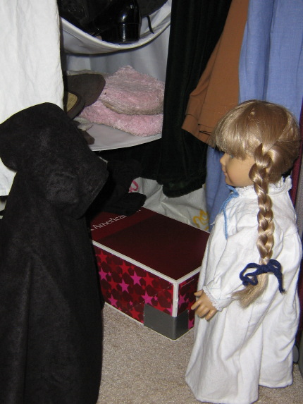 Kirsten and the Ghost are in a closet, with a doll box in the floor.