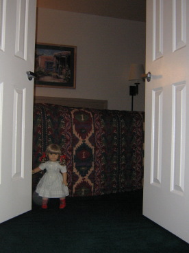 Kirsten goes through a double-doorway to a bedroom.