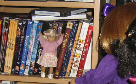 Mini Kit stands on the DVD shelf, enthusiastically suggesting a film.