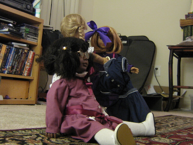 May sits down in front of Kirsten and Nellie.  (Nellie is holding her swimsuit.)