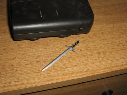 Mini Kit's sword is left behind on the dresser, next to a clock radio.