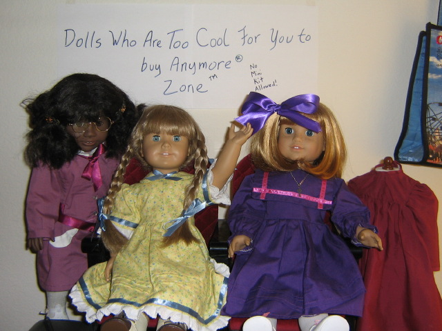 May, Kirsten, Nellie, and Pegleg Sally are on theater seats on a shelf in front of a sign that reads "Dolls Who Are Too Cool For You To Own (R) Zone TM  No Mini Kit Allowed
