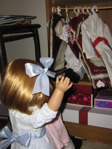 Nellie spies a foot in the doll clothes-rack!